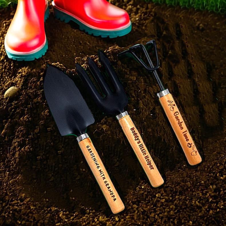 Engraved kids garden tools set in soil